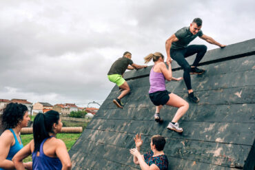 Group,Of,Participants,In,An,Obstacle,Course,Climbing,A,Pyramid